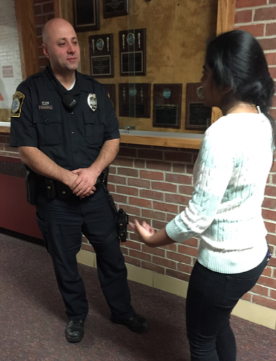 Police force-- Officer Ferrik Mustafai and senior Niki Patel discuss issues in the hallway. Mustafai took over the position of SRO after Joanna Blumetti returned to the patrol division.