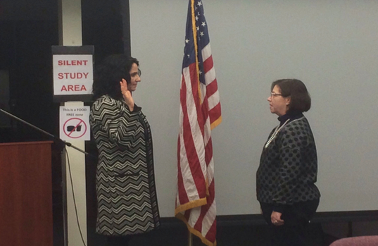 Seeing red-- Newly-elected Board members Mecheal Hamilton (left) is sworn in by town clerk Paula Ray (right). Hamilton was one of three new Board members elected for the 2016-17 Board term.