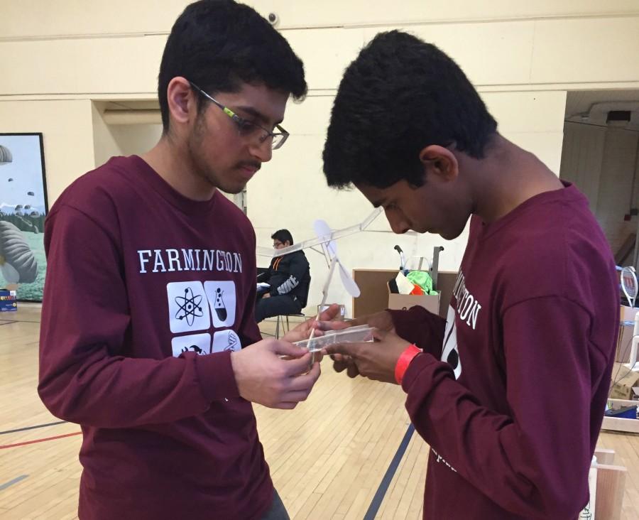 Preparing for takeoff-- Sophomore Amir Suhail and freshman Vishanth Palanivel file down the wings on the rubber band-powered plane prior to the competition for the event Wright Stuff. The duo launched their plane and was scored on the amount of time that it spent in the air. They placed seventh out of the teams that competed in this event. 
