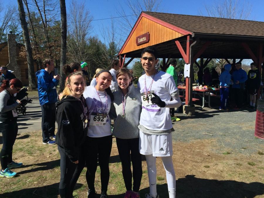 Sophomores Vini Munshi and Olivia Bottalico show off their medals alongside social studies teacher Emma Tuthill and English teacher Katie Buckley after running the 5K on April 10. 