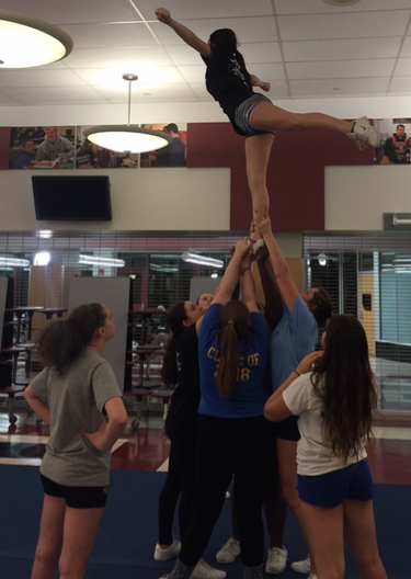 Cheerleaders work hard at their after school practices in the cafeteria. Sophomore Taylor Terrenzi practices hitting an arabesque with her stunt group for their upcoming competitions on January 30, February 13 and 27.