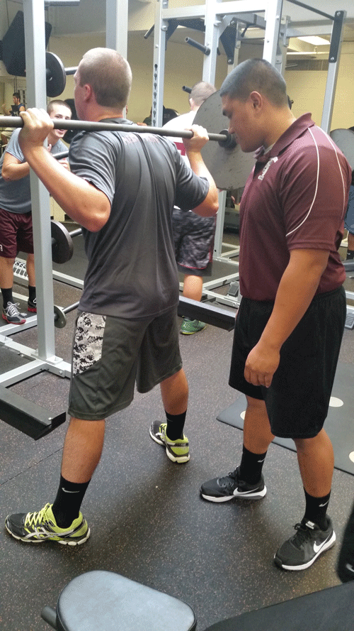 Strength and conditioning coach Jay Mendoza spots junior Ryan Witter as he lifts. Mendoza was hired this year to support the sports teams.