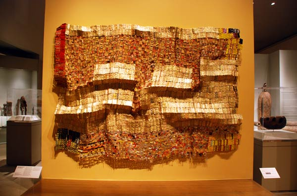 West African wall art-- “Between Earth and Heaven” is a metal tapestry that can be viewed at the Metropolitan Museum of Art. West African artist El Anatsui created the art with techniques both traditional and modern.