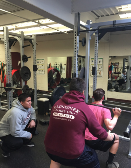 Breathe in, exhale out--Junior Matt Lynch squats as junior Murphy Gruninger and Coach Jay Mendoza spot him during a club meeting after school. The club began meeting in early January. 