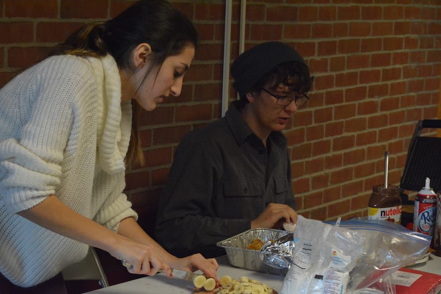 Pass the Nutella-- Seniors Noor Taweh and Hunter Caouette make crepes for students in teachers in the morning before classes start. Crepes were sold all week as part of National French Week to spread awareness for the culture.