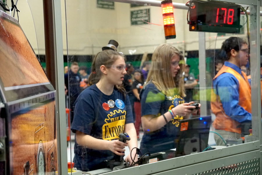 Hands up-- Senior Jamie Poole (right) and freshman Emma Nollman (left) drive their robot during one of their semifinal matches. The team made it to the finals with the help from their alliance partners, Sim-City (Simsbury, Connecticut) and Bobcat Robotics (South Windsor, Connecticut). 