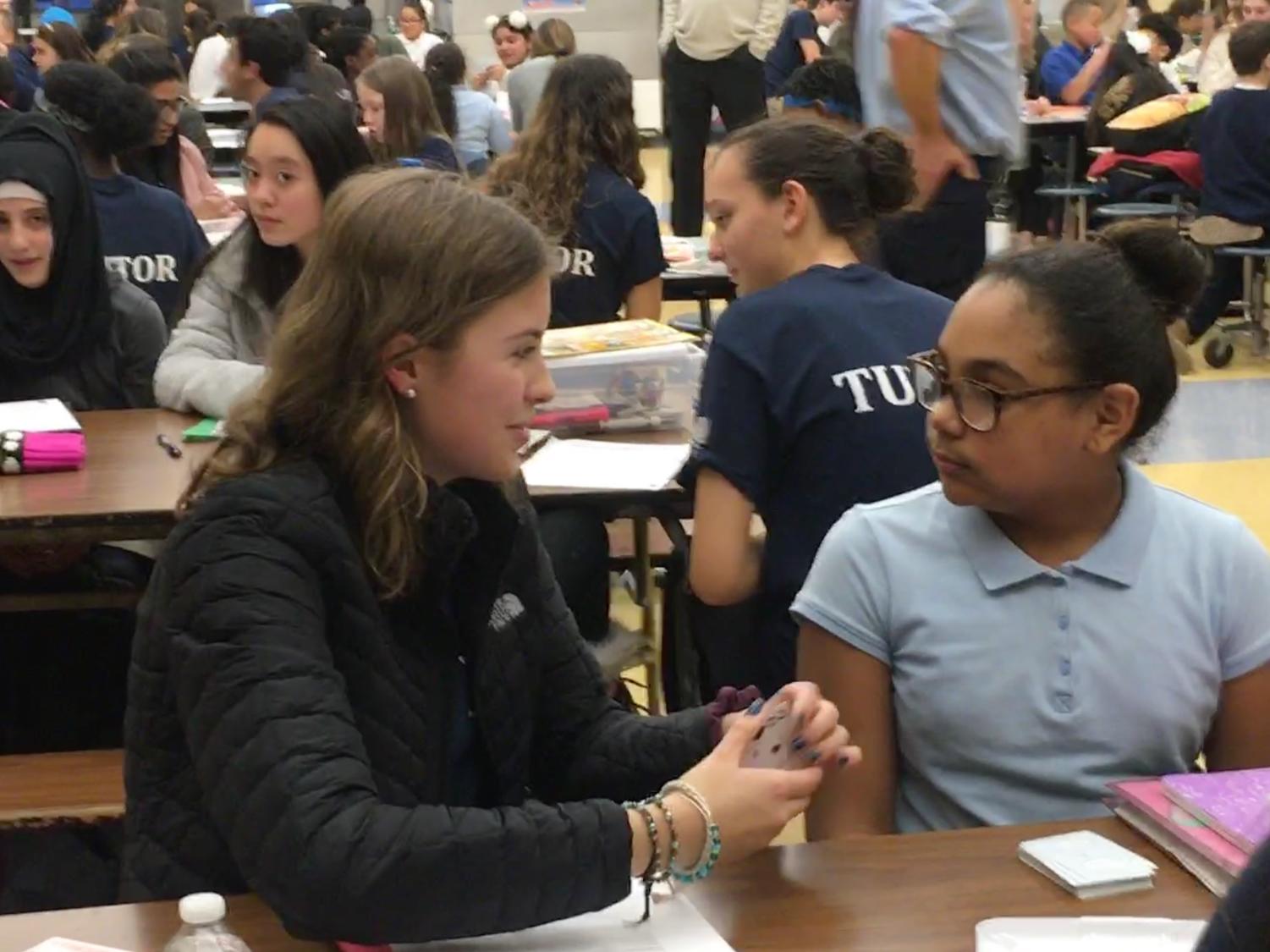 Here to help--Sophomore Maddy Jobin gets to know her assigned student from Vance Elementary during the first tutoring session. Students from the high school volunteer on thursdays after school to tutor at the elementary school.
