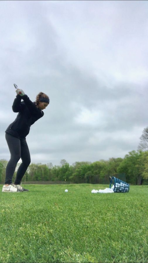 Swinging into the tournament-- Junior captain Mia Grzywinski gets some extra practice in despite the gloomy weather. The golf team finished the regular season with a 9-3 record.