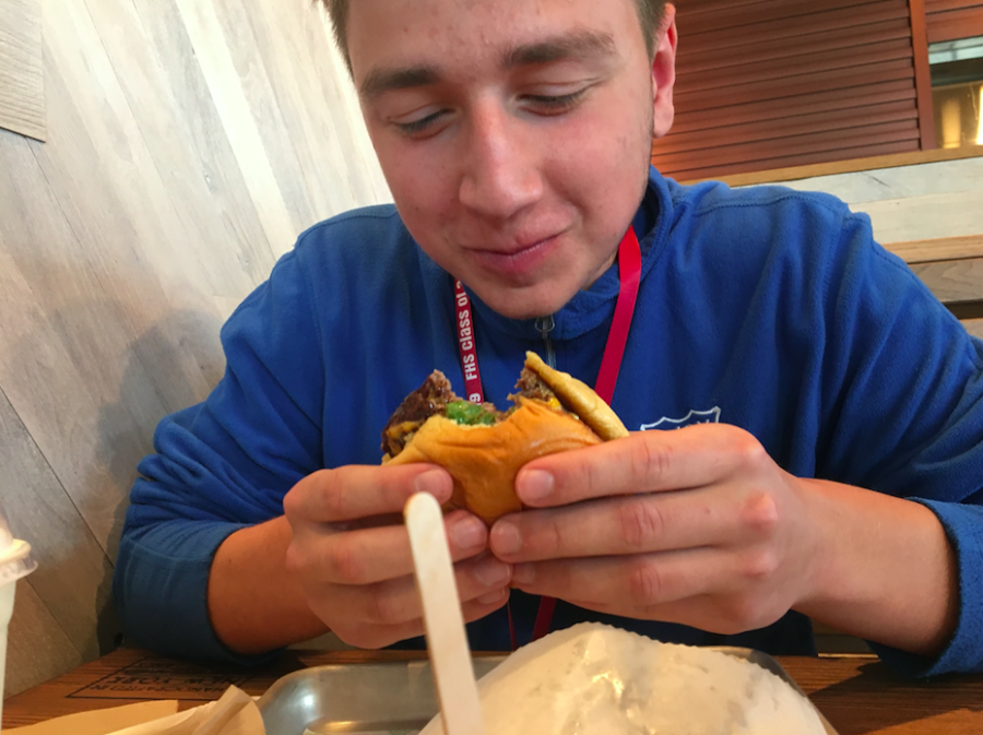 Mouthwatering-- Junior Ethan Blumes bites into a burger at Shake Shack. The chain restaurant opened their second Connecticut location
in West Hartford on April 27.