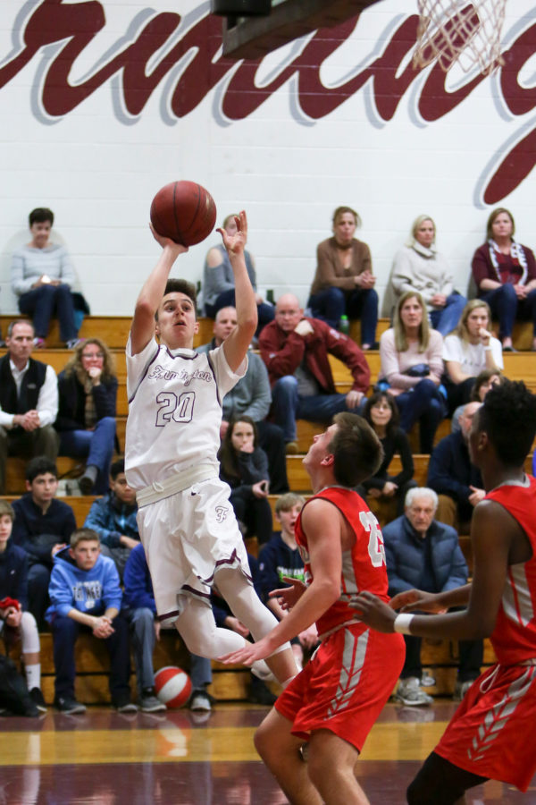 Jumping into the season-- Junior point guard Grayson Herr goes up for the shot during the teams game against Conard last year. The home opener will take place on December 15 versus Buckley. 
