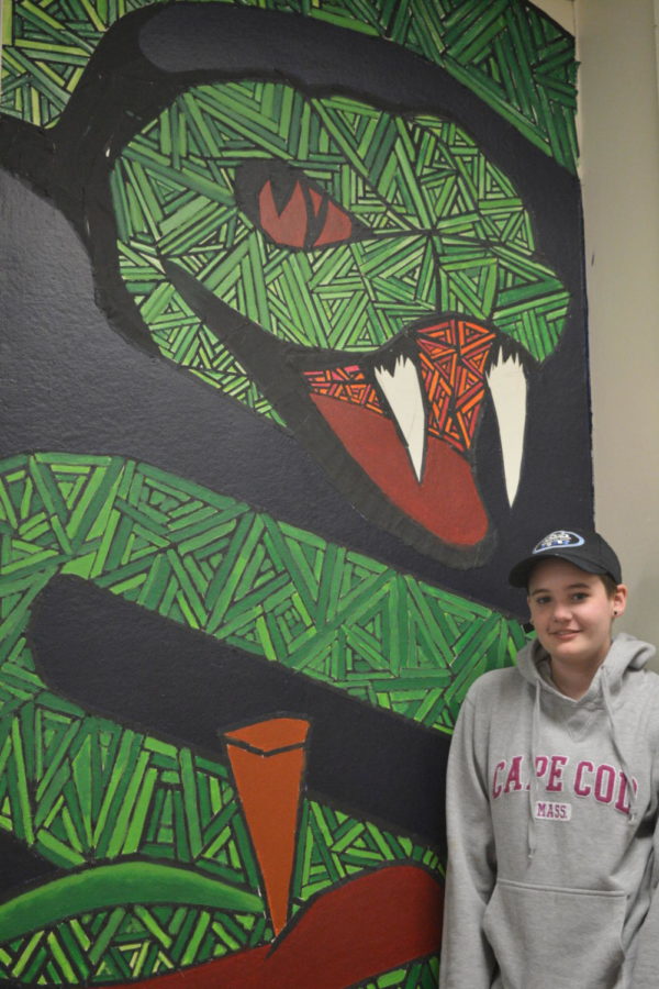Picture perfect-- Junior Emma Fink poses in front of her serpent mural in the art wing. Fink has loved art ever since she was four
years old, and prefers drawing and sketching.