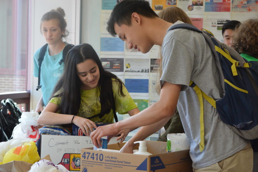 So much food-- Junior Grace Libucha (left) works with junior Jordan Song (right) to organize food for the local food pantry on Community Giveback Day, which occurred on May 24. Libucha and Song are in English teacher MJ Martinez's and Student Activities Director Russ Crist's Connect groups, respectively. Other Connect rooms participated in the "campus crawl" or in writing letters to veterans.