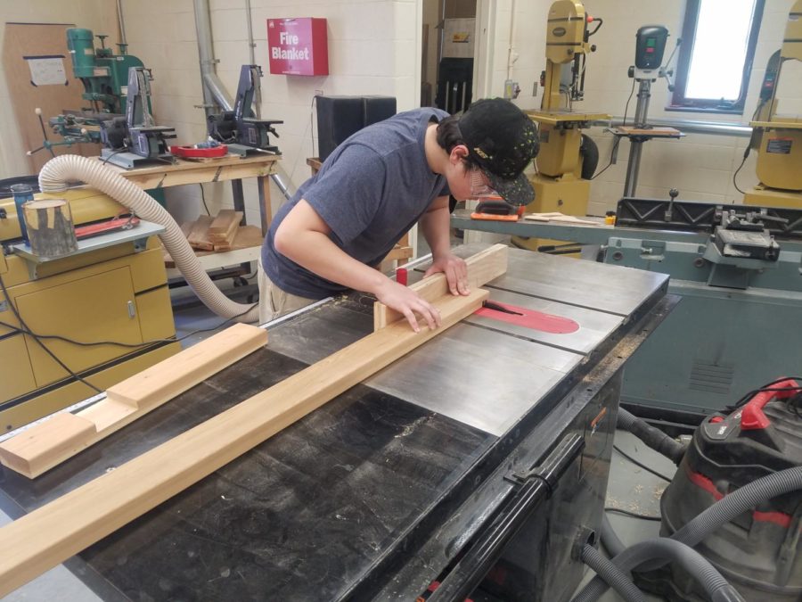 In loving memory-- Senior Joe Kall works on creating a memorial bench in memory of the late Department Leader of Library, Media and Technology K-12 Martha Burr. Kall completed the bench as part of his Custom Capstone project.