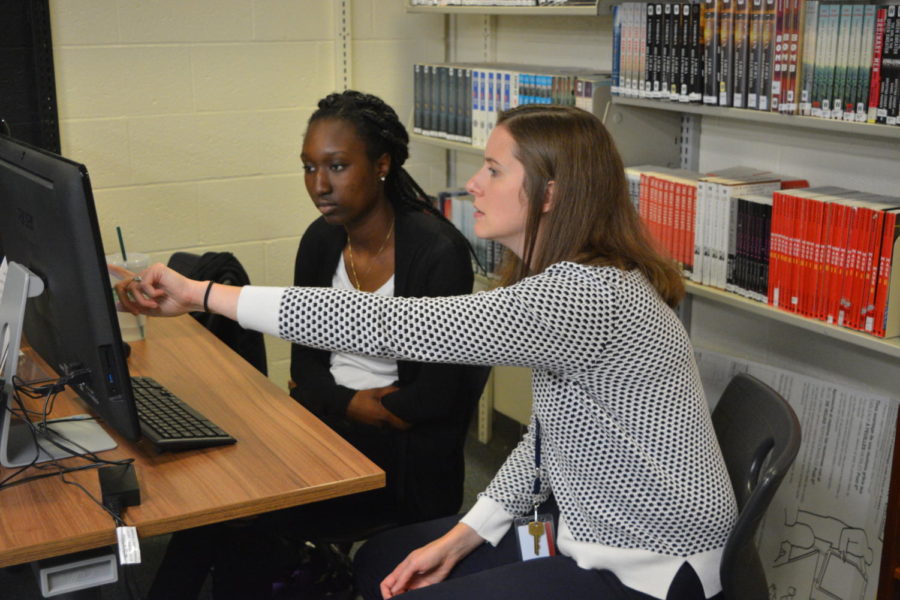 Ready to write-- Senior Daphne Dibgolongo receives help with her writing from Writing Fellowship teacher Shea Benton-Reger. The writing center is
located under the stairs in the school library. 