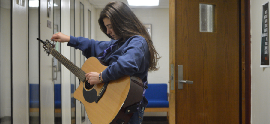 Tuning up-- Senior Zoe Cozentino adjusts her strings before taking the stage at the Senior Cafe. This years Senior Cafe took place on October 25,
and featured numerous performances by students throughout the school.