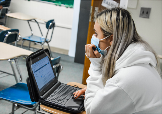 Adapting for Success-- Senior Abby Kosakowski attending Aspire course while connecting with classmates
online while wearing a mask promoting social distancing guidelines to be on track to achieve the Vision of the Global Citizen requirements