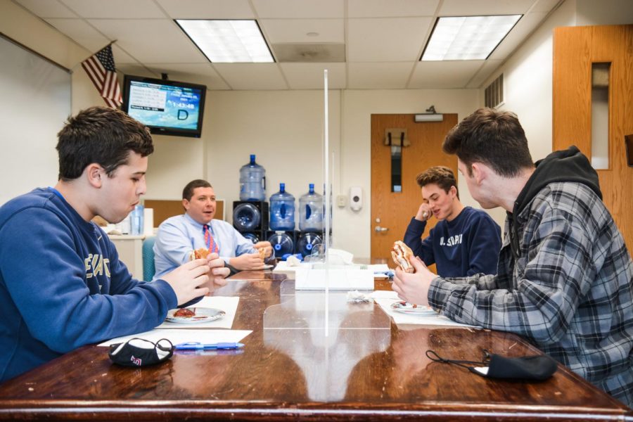 Bites of happiness-- Seniors Hollis Tharpe (left front), Ricky Podgorski (right front), John Guerrera (right back) and Principal Scott Hurwitz (left back) taste test

chicken parm grinders in a blind taste test. Claudia’s Grinder Shop was declared the winner, beating out Naples, George’s, and Franklin Ave.
Grinder Shop. The grinders were assessed on their freshness, sauce to cheese ratio, structural integrity, and chicken quality.