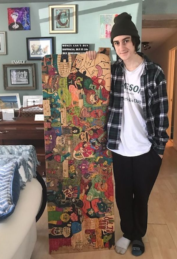 A true creator-- Senior Jameson Canny shows off his quarantine work.
During quarantine, Canny used a piece of wood as his homework and
drawing desk, which he covered with various doodles.