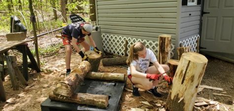 Carving for a cause-- Sophomore Thatcher Gorman (left) and junior Gabby Gorman (right) work on building a Farmington tiki for the Tiki Task Force raffle. Senior Senan Gorman created the Tiki Task Force to raise money for the Jack Phelan Scholarship fund. 