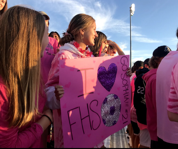 All+out+for+Pink+Out+%E2%80%94+Sophomore+Lila+Manton+dressed+in+pink+holds+up+a+sign+to+support+the+girls+soccer+team+on+their+annual+%E2%80%9CPink+Out%E2%80%9D+on+September+24+to+raise+awareness+for+breast+cancer.+Manton+was+in+the+student+section%2C+named+%E2%80%98The+Flock%E2%80%99%2C+led+by+the+seven+super+fans.+