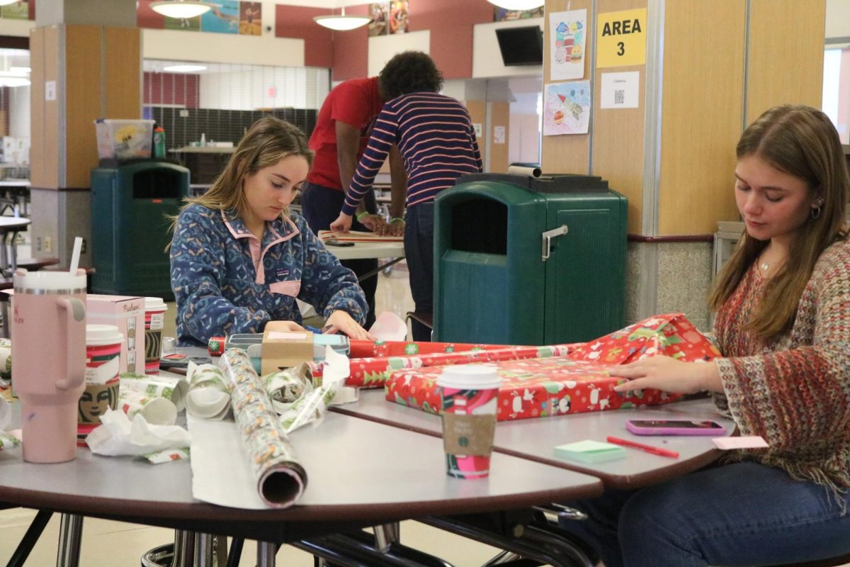 That%E2%80%99s+a+wrap--+Members+of+the+National+Honor+Society+wrap+gifts+for+the+annual+NHS+gift+wrap+drive.+Students+volunteered+after+school+in+the+Farmington+High+School+%28FHS%29+cafeteria+on+December+7+and+8+to+wrap+teacher%E2%80%99s+holiday+gifts.