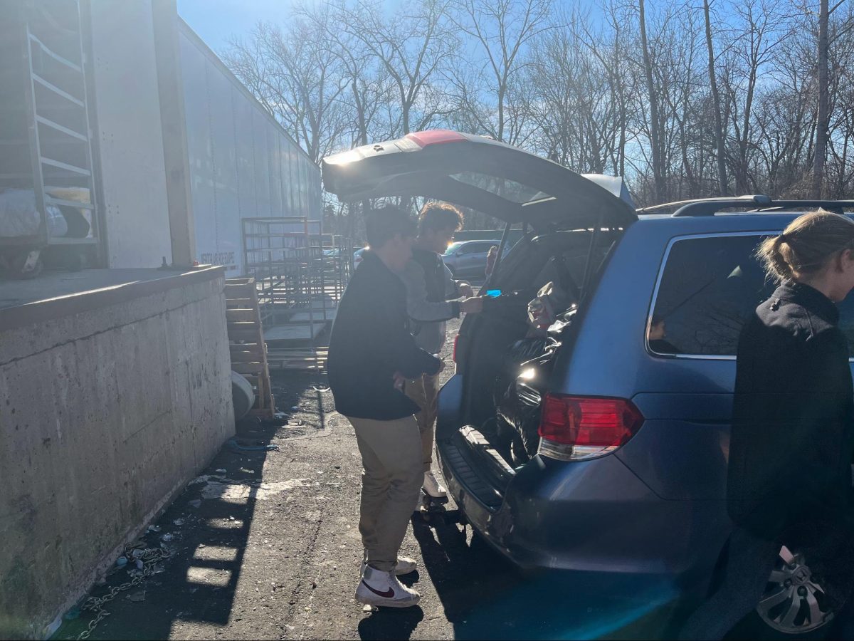 Hard at work to help the community!- -Seniors Andrew Ranucci, Nick Bergin, and Reagan Olivastro help distribute old clothes and household items to a nearby Savers. Student volunteers helped collect donations that were then packed into cars and sent to the retail store. 