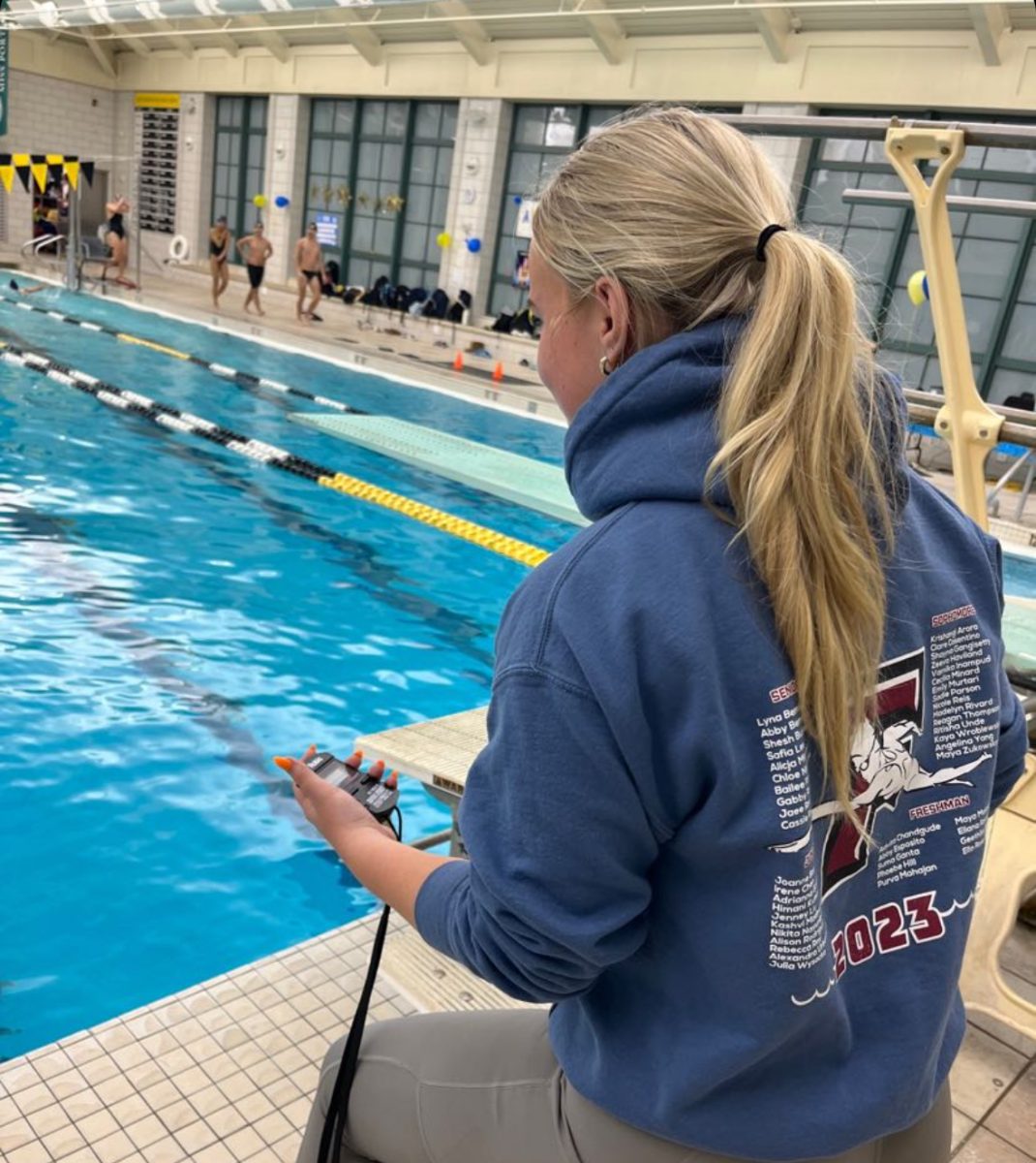 Swim saviors— The boys swim team thrives with the help of fellow peers to time them, get materials, and cheer them on. Swim manager Julia Wysocka timed swimmers while they competed against Simsbury at Westminster High School on February 21, 2024.